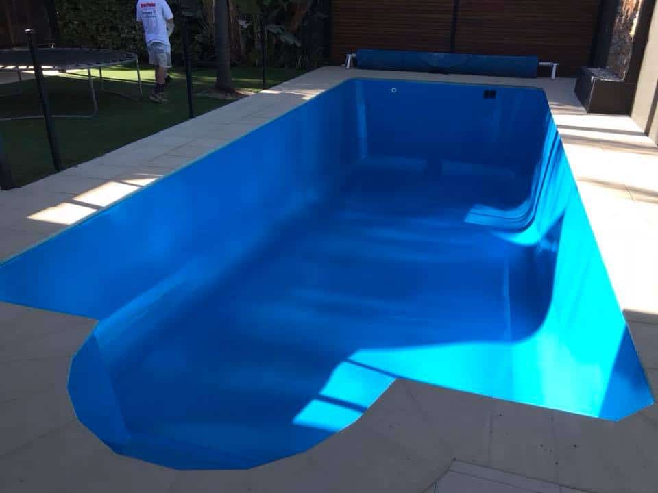 Adelaide concrete pool after resurfacing by Blue Revive — flawless deep blue finish, modern fenced surround