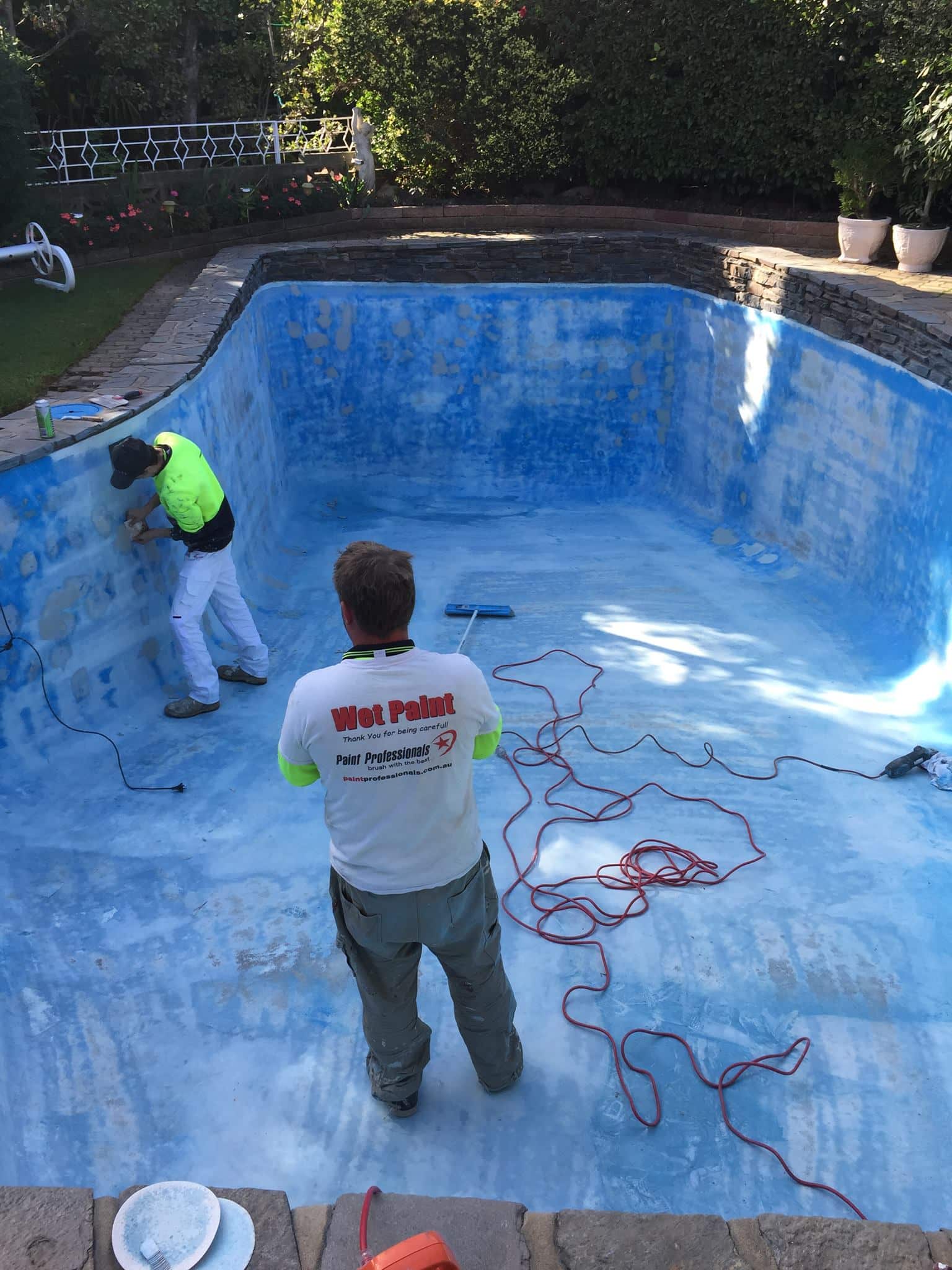 Adelaide concrete pool during restoration prep — old surface stripped back by Blue Revive crew, stone coping surrounds